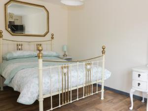 a bedroom with a white bed and a mirror at Foxley Wood Cottage in Horsham Saint Faith