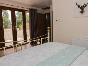 a bedroom with a bed and a large window at Foxley Wood Cottage in Horsham Saint Faith