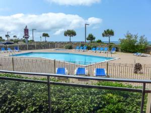 Chambre-dʼAmour的住宿－Apartment Mer et Golf by Interhome，一个带蓝色躺椅的游泳池和大海