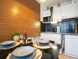 a kitchen with a table with plates and wine glasses at Apartment Mer et Golf by Interhome in Chambre-dʼAmour