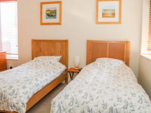 a bedroom with two twin beds and a night stand at Harbour View, Mudeford in Christchurch