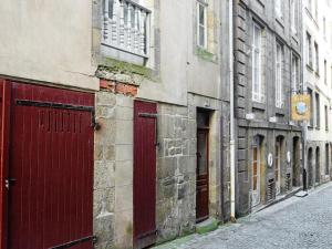 an old building with red doors on a street at Apartment Saint Thomas by Interhome in Saint Malo