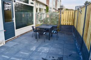 a patio with a table and chairs and a fence at De Wulk 26 in Zandvoort