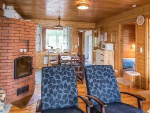 een woonkamer met een tafel en stoelen en een open haard bij Holiday Home Kettukallio by Interhome in Luhtanen