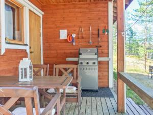 a porch of a cabin with a stove and a table at Holiday Home Kettukallio by Interhome in Luhtanen