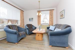 ein Wohnzimmer mit 2 Stühlen und einem Tisch in der Unterkunft Ferienwohnungen im Haus am Wattenmeer in Neuharlingersiel