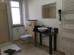 a bathroom with a sink and a toilet at Hotel Schwarzes Ross in Ganderkesee