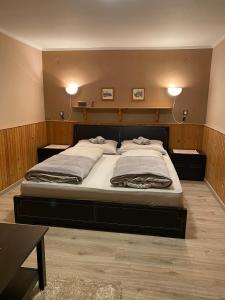 een slaapkamer met een groot bed met 2 verlichting bij Privát Vavrúš in Donovaly