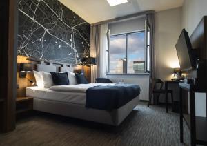 Cette chambre comprend un grand lit et une fenêtre. dans l'établissement Best Western Hotel Mariacki Katowice, à Katowice