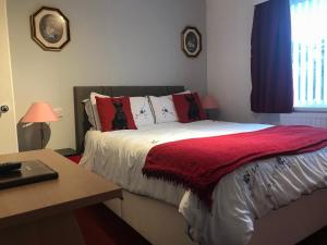 a bedroom with a bed with a red blanket on it at Great Western Hotel Guest House in Paignton