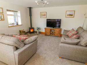 a living room with two couches and a flat screen tv at Stable View Cottage in Clitheroe