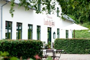 a white building with a table and an umbrella at Julsø lejligheden in Silkeborg