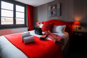 a bed with a red blanket on top of it at Alexandra in Lyon