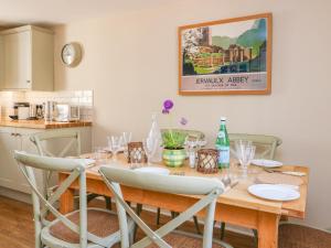 - une table à manger avec des chaises et une table en bois dans l'établissement Orchard Cottage, à East Witton