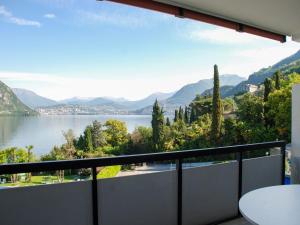 ビッソーネにあるApartment Lago di Lugano-4 by Interhomeの湖と山々の景色を望むバルコニー