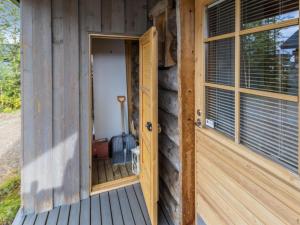 an open door of a wooden house with a window at Holiday Home Kukasrakka c10 by Interhome in Äkäslompolo