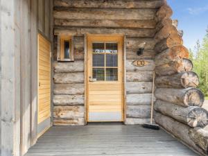 a wooden door of a log cabin with a porch at Holiday Home Kukasrakka c10 by Interhome in Äkäslompolo