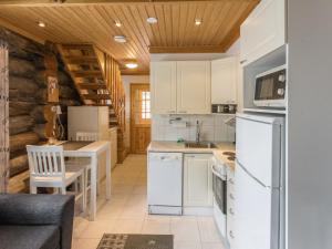 a kitchen with white appliances and wooden ceilings at Holiday Home Kukasrakka c10 by Interhome in Äkäslompolo +7 photos