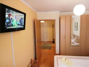 ルーポルディングにあるApartment Bibelöd-6 by Interhomeの壁にテレビが付いた客室で、ベッドが備わります。