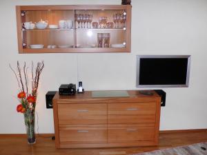 einen Fernseher auf einer hölzernen Kommode mit einer Blumenvase in der Unterkunft Apartment Bibelöd-6 by Interhome in Ruhpolding