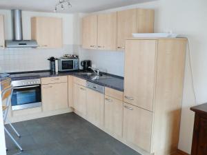 una cucina con armadi in legno, lavandino e piano cottura di Apartment Bibelöd-7 by Interhome a Ruhpolding