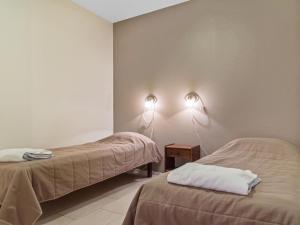 アカスロンポロにあるHoliday Home Yllästar 3 as 609 by Interhomeのベッド2台と壁に照明2つが備わる客室です。