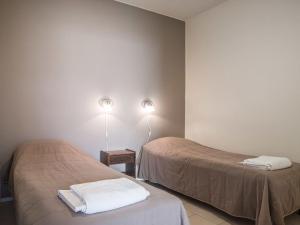 アカスロンポロにあるHoliday Home Yllästar 3 as 508 by Interhomeのベッド2台と壁に照明2つが備わる客室です。
