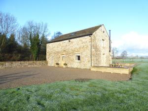 an old stone building with a picnic table in front of it at Cow Hill Laith Barn in Sawley