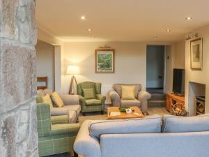 a living room with couches and chairs and a tv at Fogga Croft Cottage in Skipton