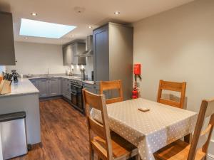 a kitchen and dining room with a table and chairs at Fogga Croft Cottage in Skipton
