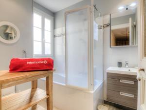 a bathroom with a shower and a red bag on a table at Apartment La Plage-1 by Interhome in Dinard
