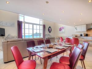 a dining room with a table and red chairs at Apartment La Plage-1 by Interhome in Dinard