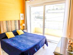 ビアリッツにあるApartment Les Jardins du Princeのベッドルーム(青いベッド1台、大きな窓付)