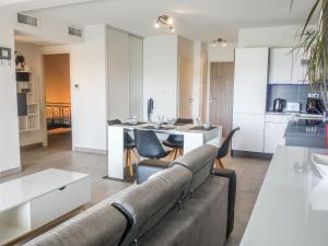 Il comprend un salon avec un canapé et une cuisine. dans l'établissement Apartment Terrasse de Lucie by Interhome, à Saint-Cyprien