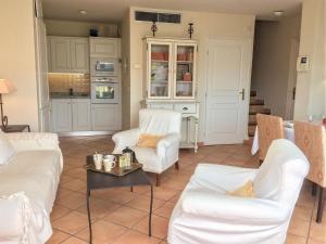 a living room with two white chairs and a table at Apartment Le Panoramic by Interhome in Sainte-Maxime