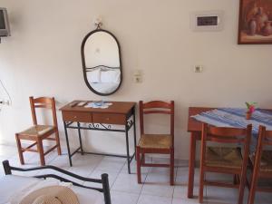 a dining room with a table and a mirror at Porto Kastri Studios in Kastrí