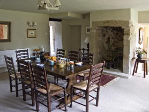 uma sala de jantar com uma mesa de madeira e cadeiras em Town Head Farm em Malham
