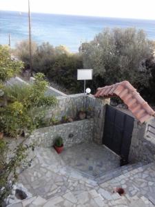 a stone wall with a gate in front of the ocean at Porto Kastri Studios in Kastrí