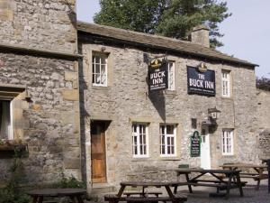 a stone building with picnic tables in front of it at Town Head Farm in Malham