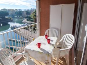 サン・シプリアン・プラージュにあるApartment Marina Village by Interhomeのテーブルと椅子、川の景色を望むバルコニー