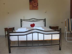 a bed with a red heart sitting on top of it at Porto Kastri Studios in Kastrí