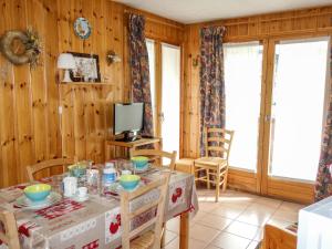 a dining room with a table and chairs and a television at Apartment Les Jardins Alpins-5 by Interhome in Saint-Gervais-les-Bains