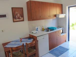 a kitchen with a sink and a table with chairs at Porto Kastri Studios in Kastrí
