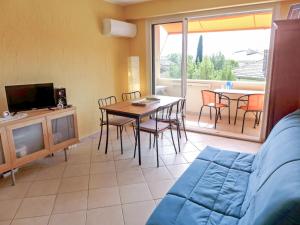 sala de estar con sofá y mesa con sillas en Apartment Les Vignes by Interhome, en Les Lecques