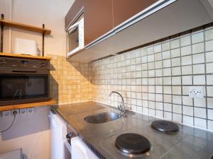 a kitchen with a sink and a microwave at Apartment Vanoise 152 by Interhome in Val Thorens +16 photos