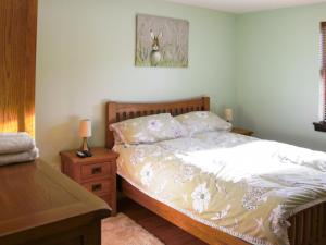 a bedroom with a bed and a wooden dresser with a bed sidx sidx sidx at Holiday Home Glenn Cottage by Interhome in Uig