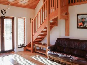 a living room with a staircase and a leather couch at Holiday Home Glenn Cottage by Interhome in Uig