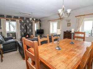 a dining room and living room with a wooden table at Bowden Head Farmhouse Cottage in Highpeak Junction