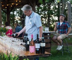 een man die wijn in wijnglazen giet op een tafel bij Stevenson Farms-Harvest Spa B & B in Alliston