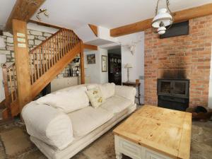 een woonkamer met een witte bank en een bakstenen muur bij Mill House in Dorchester